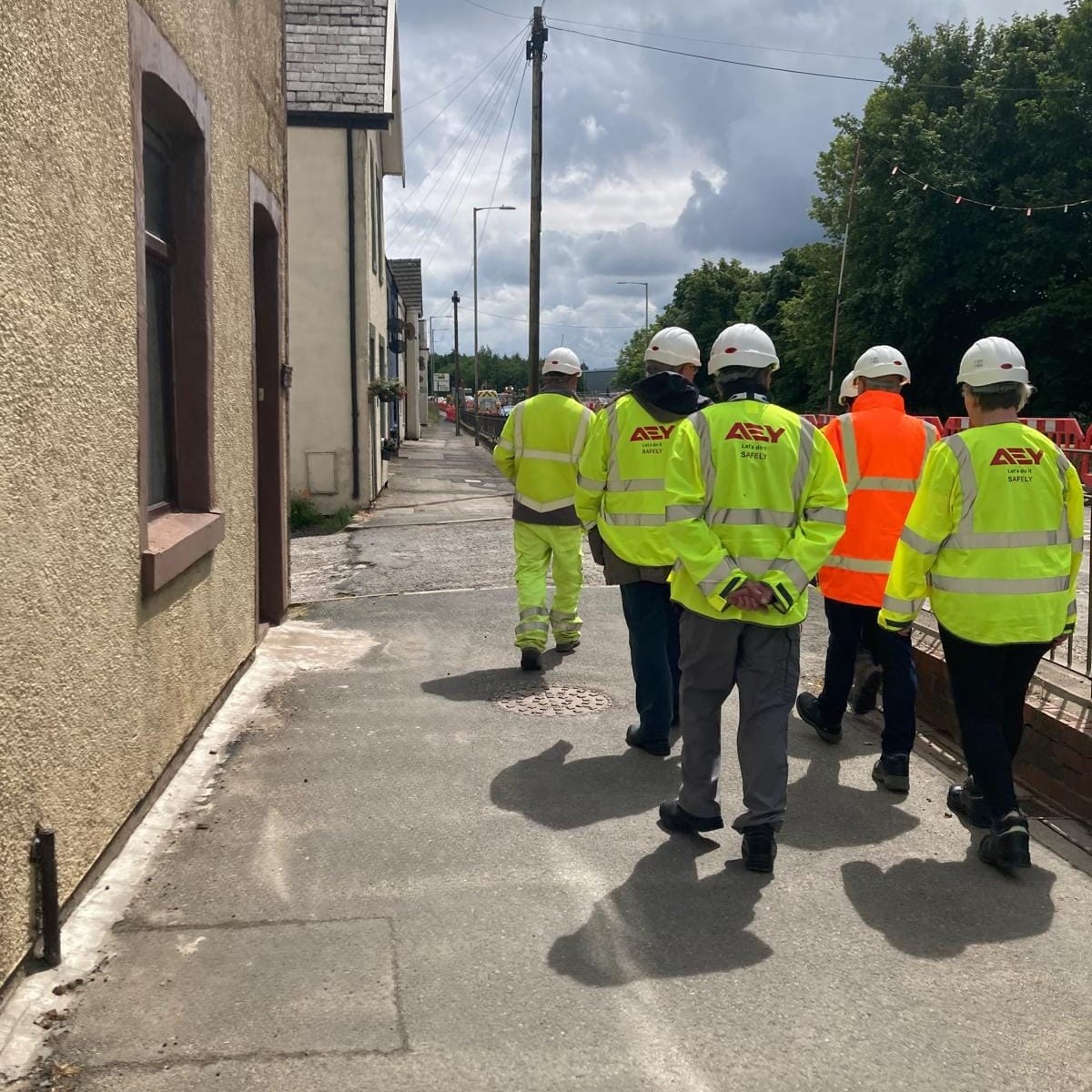 Councillors and contractors walk by the Bluebell Cottages on a site visit yesterday