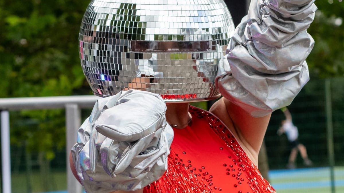 A Disco Ball Lady dances in front of the stage, delighting the crowd