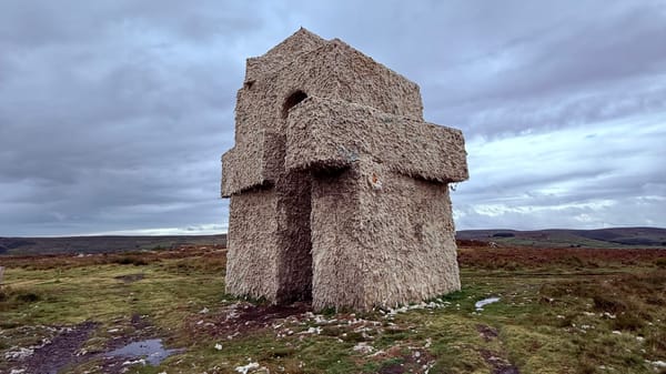 A monumental archway that from a distance looks hewn from rock but is made from the raw fleece of local sheep